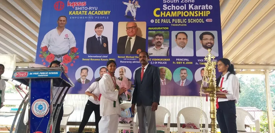 Stage with the South Zone School Karate Championship banner and trophy at De Paul Public School, Thodupuzha